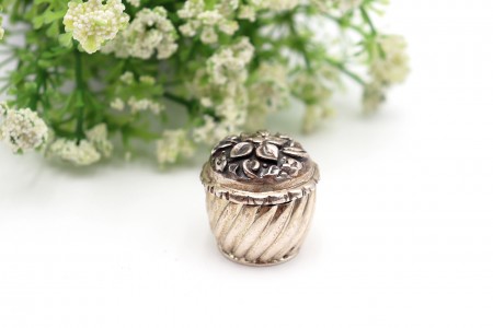 Caixa de comprimidos em prata canelada com flor em alto relevo na tampa